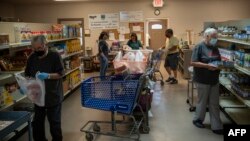 美国新墨西哥州的志愿者在一个食物库里准备装满食品袋捐助穷人。(2020年5月7日)