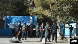 Policemen stand guard at an entrance gate of the Kabul University in Kabul on November 2, 2020.