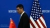 2023年8月28日,商务部长吉娜·雷蒙多(Gina Raimondo)和中国商务部部长王文涛在北京商务部会晤前,一名中国官员走过中美两国国旗。