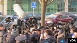 许志永的律师张庆方与庭外外国记者交谈时,受到警察和便衣警察的阻挡,场面一度混乱(美国之音东方拍摄)