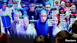 中国福建省福州市举办的中国数字技术展览会上参观者的脸部在人脸识别技术屏幕上显示。(2019年5月8日)
