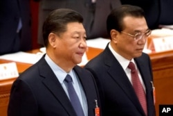 资料照:中国国家主席习近平与总理李克强在北京人大会堂出席全国人大会议闭幕式。(2019年3月15日)