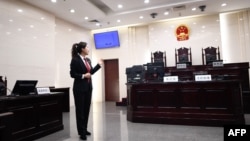 资料照片:一名中国人民最高法院的工作人员站在法庭内向参观者做介绍。(2018年12月20日)