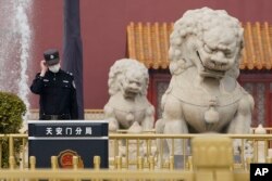 一名警察站在北京天安门城楼旁的石狮子边执勤。(2021年3月11日)