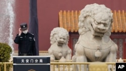 中国警察守卫在北京天安门前的石狮子旁。(2021年3月11日)