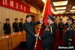 中国国家主席习近平(左前)在北京举行的中国人民解放军战区成立大会上向五大战区授予军旗。(2016年2月1日)