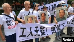 人们在中国广东省深圳市坪山区燕子岭派出所外示威,手持标语,支持佳士工厂工人组建工会要求。(2018年8月6日)