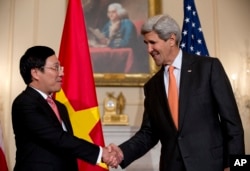 美国国务卿约翰•克里与越南副总理兼外长范平明在美国国务院握手。(2014年10月2日)