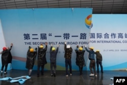 在第二届一带一路国际合作高峰论坛闭幕后,中国工人拆掉宣传板。(2019年4月27日)