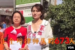 709案律师王全璋的妻子李文足(右)和李和平妻子王峭岭到最高递控告状。李文足和王峭岭到中国最高法提交控告书,控诉各级司法部门在709案中的违法行为,在最高法院外,李文足手举控告书,她的衣服上贴有“王全璋回家”字样(2017年5月12日,推特图片)。