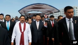 2014年9月17日,习近平主席和斯里兰卡总统拉贾帕克萨(身穿白衣者)在启动科伦坡的港口城项目后一起行走