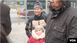 2015年12月22日上午,维权人士倪玉兰和丈夫董继勤来到法院外声援浦志强,有便衣试图遮挡记者拍照(美国之音叶兵拍摄)