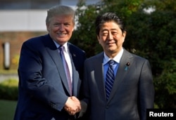 美国总统川普与日本首相安倍晋三在霞关乡村俱乐部前握手。(2017年11月5日)