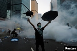 一名抗议者在香港警察向和平示威的民众施放催泪弹后举起了雨伞。(2014年9月28日)