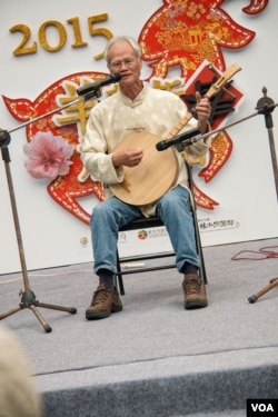 唸歌团长叶文生在台北郊区的林家花园表演月琴弹唱。(美国之音记者方正拍摄)
