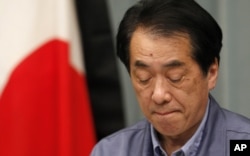 日本首相菅直人在记者会上,旁边是镶了黑边的日本国旗