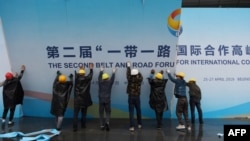 在第二届一带一路国际合作高峰论坛闭幕后,中国工人拆掉宣传板。(2019年4月27日)