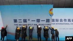 在第二届一带一路国际合作高峰论坛闭幕后,中国工人拆掉宣传板。(2019年4月27日)