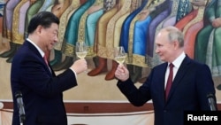 资料照片:俄罗斯总统普京与中国国家主席习近平在克里姆林宫的招待会上举杯致意。: (2023年3月21日)