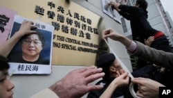 1月3日,抗议者们在香港中联办外张贴失踪的书商照片。