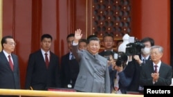 2021 年 7 月 1 日,在北京天安门广场举行的中国共产党成立 100 周年纪念活动结束时,中国国家主席习近平在李克强总理和前国家主席胡锦涛旁边挥手致意。