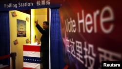 2012年11月7日,在美国驻北京大使馆组织的模拟投票中,一位客人投下自己的一票。这一票可能是支持奥巴马,也可能是支持罗姆尼。