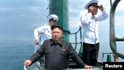 朝鲜官方媒体2014年6月公布的照片显示领导人金正恩视察一艘老旧潜艇。美国研究人员说,卫星图像分析显示,朝鲜可能已获得一艘新潜艇。