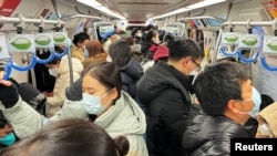 2022年12月26日的上班早高峰,北京的地铁车厢挤满了乘客。