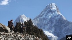 资料照:国际登山者向珠穆朗玛峰行进。