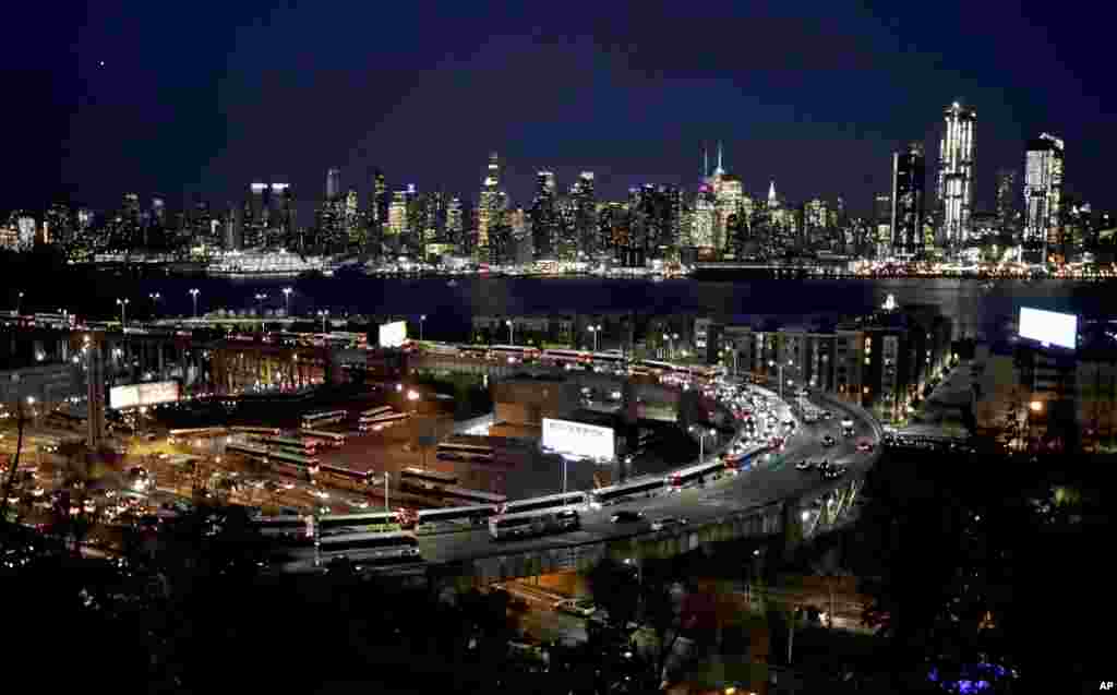 纽约之夜,林肯隧道环形公路上的车流,后面是高楼林立所构成的纽约天际线(2017年11月21日星期二)。在感恩节之前的假期旅行开始了。
