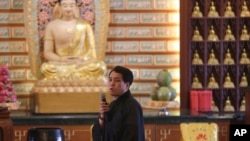 失踪马航班机中国乘客的家人在马来西亚八打灵再也的一座佛寺祈祷后讲话。(2014年3月31日 )