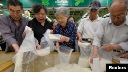 资料照:山西省太原市一家超市里的顾客在买大米。(2013年5月22日)