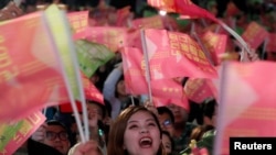 在台北民进党总部外的蔡英文总统的支持者举旗欢呼。(2020年1月11日)