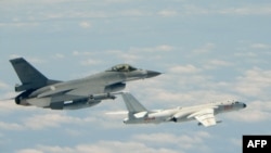 台湾空军战机F-16在台湾南部巴士海峡上空伴飞中国大陆空军轰炸机轰六K。(资料照,台湾国防部)