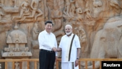 印度总理莫迪(右)与中国国家主席习近平在印度马马拉普拉姆的历史遗址前握手(2019年10月11日)。