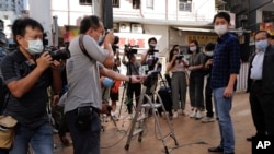 香港立法会前议员许智峰(右二)在交保获释走出警察局后被记者围住。(2020年11月18日)