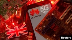 资料照:在一块电脑母版上的英国国旗和有着华为与5G网络标识的手机。(2020年1月29日)