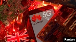 资料照:在一块电脑母版上的英国国旗和有着华为与5G网络标识的手机。(2020年1月29日)