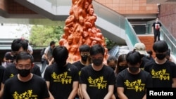 香港大学的学生在悼念六四死难者的“国殇之柱”前向死难者默哀。(2021年6月4日)