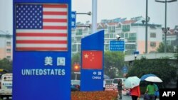 资料照:中国山东青岛商店外的中国和美国国旗。(2018年9月19日)