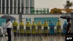 位于深圳的恒大集团总部外警察穿着雨衣在站岗。(2021年9月14日)