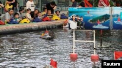 2018年6月2日,中国上海的一家公园,儿童玩耍遥控模型军舰。