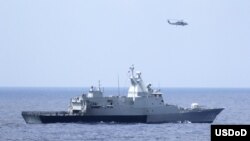3月12日美国海军直升机与马来西亚海军配合搜寻失踪的马航370班机(图片由美国海军提供)