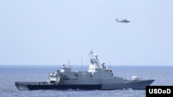 3月12日美国海军直升机与马来西亚海军配合搜寻失踪的马航370班机(图片由美国海军提供)