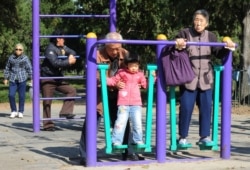 资料照:北京天坛公园里的老年人和他们的独生子女的孙辈在锻炼身体。(2011年10月25日)
