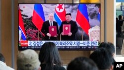 2024年11月12日,在韩国首尔火车站的一档新闻节目中,电视屏幕上显示了朝鲜领导人金正恩和俄罗斯总统普京在平壤的照片。