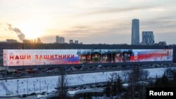 Надпис на постері у Москві з фотографіями російських військових: "Наші захисники. Спасибі, рідні!", 21 лютого 2025 року. REUTERS/Yulia Morozova