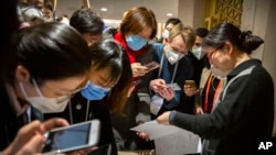 记者们在北京国务院新闻办公室阅读中国政府声明。(2020年1月26日)