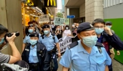 香港支联会及社民连4名成员4月15日首个国家安全教育日游行示威,被大批军装警员包围 (美国之音/汤惠芸)