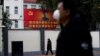 戴着口罩的行人走过上海街头习近平的画像。(2020年2月10日)
